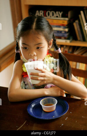 Tuesday, August 14, 2007, Carlsbad, California, USA Miranda Jiang, 7, of Oceanside, sips lemonade after finishing her caramel and apple snack in between her art lesson in watercolor painting in Carlsbad.   teaches art lessons to kids and adults. The story is also previewing a class she will teach on Stock Photo