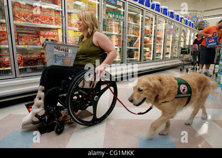 PAMELA ALBERTSON, age 37, shops for groceries at Ralph's grocery store in Point Loma with her golden retriever, 'Cameo,' age 10, a golden retriever service dog.  Her boyfriend, JOHN CARPENTER, age 43, also came to shop with her.  Apparently, more and more people are faking service dogs. They go onli Stock Photo