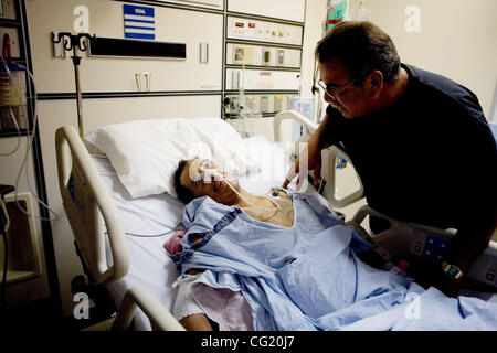 PHOTO TAKEN WEDNESDAY AUG 29, 2007. Jesse Garcia, holds his son, Javier Garcia's hand as he sits in a hospital bed due to complications from contracting Yellow fever while inside pleasant valley state prison in Coalinga, CA, Wednesday Aug. 29, 2007. Javier died Friday morning, Oct. 12, 2007. Sacrame Stock Photo