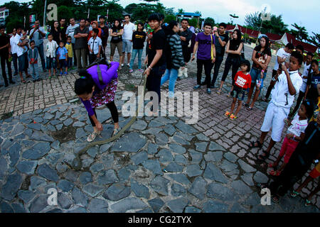 October 25, 2011 - Bintan, Sumatra, Indonesia - Petrisia Zahra (right), Chazanatul Imani (centre) and Igha Anjani Seha (left) playing with King Cobra on October 25, 2011 Bintan, Indonesia. Indonesia as a tropical country as the richest country in the types of insects. King Cobra was arrested two wee Stock Photo