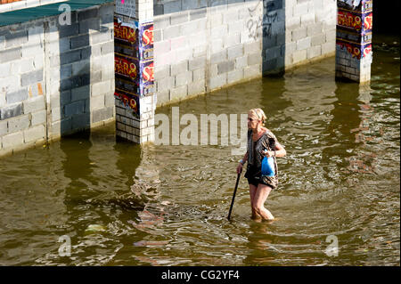Nov. 10, 2011 - Bangkok, Thailand - A woman walks through floodwaters in Bangkok, Thailand. Floodwaters are creeping further into city's center. Thailand is suffering from worst flooding in 50 years. Over 400 people have died due to flooding since late July according to Department of Disaster Preven Stock Photo