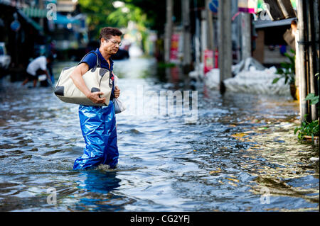Nov. 10, 2011 - Bangkok, Thailand - A Thai resident wade through floodwaters in Bangkok, Thailand. Floodwaters are creeping further into city's center. Thailand is suffering from worst flooding in 50 years. Over 400 people have died due to flooding since late July according to Department of Disaster Stock Photo