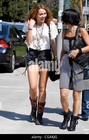 Miley Cyrus walking with a friend in Westwood wearing cut-off denim shorts Los Angeles, California - 30.09.10 Stock Photo