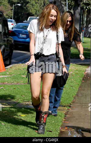 Miley Cyrus walking with a friend in Westwood wearing cut-off denim shorts Los Angeles, California - 30.09.10 Stock Photo