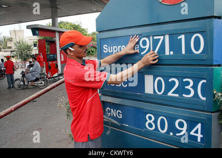 Fuel station employee displays new prices of petroleum  products at a fuel station in Karachi on Thursday, August 23, 2012. Pakistan Oil and Gas  Regulatory Authority (OGRA) were increased petroleum products and CNG due to the global  rise in oil. Stock Photo