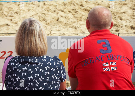 Boscombe Beach, Bournemouth, UK Saturday 25 August 2012. Finals of the Volleyball England Beach Tour (VEBT) are being held at Boscombe beach over the Bank Holiday weekend 25-26 August. Top class volleyball players battle it out to become the National Beach Volleyball Champions of 2012. Couple sat in free grand stand watching the game Stock Photo