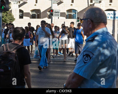 27th Aug 2012. A police officer oversees a major pedestrian crossing on Herzl Boulevard allowing safe access to students near Ziv High School on the first day of the school year. Jerusalem, Israel. 27-Aug-2012.   Israeli children go back to school today, abolishing traditional Sept. 1st date, in a first stage of reforms initiated by Ministry of Education aiming to shorten summer vacation to 6 weeks, partially relieving parents of enormous financial expenses. Stock Photo