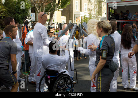 London UK. 29th Aug 2012. The Paralympic flame is passed between torchbearers in Carlton Hill, St. John's Wood on the last day of its journey to the Olympic Stadium, Wednesday 29 August 2012. Credit:  Richard Slater / Alamy Live News