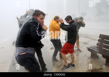 August 29, 2012 - Gulfport, Mississippi, U.S. - A group of friends, from left, JAMES NEWKIRK, ROBERT TAYLOR, CHAISE TAYLOR and MIKE NEWKIRK stand against strong wind and driving rain on the beach as Hurricane Isaac blows across the Mississippi Gulf Coast on Wednesday.  Stock Photo