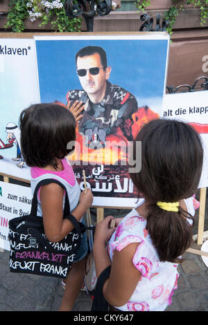 Saturday 1st September 2012. Young girls look at portrait of Assad at Syrian Pro-Assad demonstrators protest against against civil war in Syria and against outside involvement by the US and UN in historic Römerberg square in central Frankfurt Germany. Stock Photo