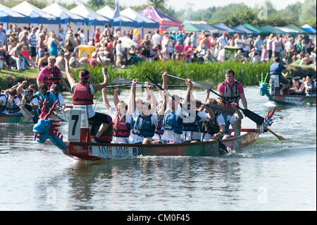 CAmbridge, UK. 8th September 2012. Competitors enjoy the late summer weather at the Cambridge Dragon Boat Festival,  on the River Cam at Fen Ditton Cambridge UK, 8th September 2012.  Around 50 crews from local organisations took part in the races paddling the 30 foot long Chinese dragon boats to raise money for the East Anglian Children's Hospices. Credit:  Julian Eales / Alamy Live News Stock Photo