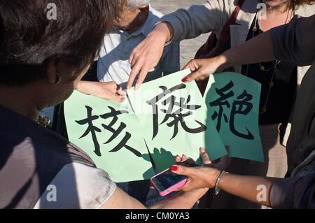 Hibakusha, Hiroshima children survivors, prepare three pages of kanji that together comprise “nuclear abolition” at the Western Wall. Jerusalem, Israel. 10-September-2012.   Hibakusha, survivors of the August 6th, 1945 bombing of Hiroshima, visit Israel to promote  nuclear abolition. Calling “No More Hiroshimas, No More Nagasakis!” they place their prayers between the Kotel stones. Stock Photo