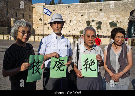 Hibakusha, Hiroshima children survivors, prepare three pages of kanji that together comprise “nuclear abolition” at the Western Wall. Jerusalem, Israel. 10-September-2012.   Hibakusha, survivors of the August 6th, 1945 bombing of Hiroshima, visit Israel to promote  nuclear abolition. Calling “No More Hiroshimas, No More Nagasakis!” they place their prayers between the Kotel stones. Stock Photo