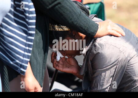 Soweto, South Africa. 11th September 2012. Nondyebo Cindi cries as bones believed to be those of her brother, Nceba Sinuma are exhumed on September 11, 2012 at Avalon Cemetery in Soweto, South Africa. Sinuma was one of the “Mofolo 3” who were killed by apartheid agents in a security operation in 1989. The Mofolo 3 were members of the Soweto Youth Congress and were involved in underground uMkhonto weSizwe activities. The body exhumed will be sent for DNA testing. (Photo by Gallo Images / Sowetan / Vathiswa Ruselo/Alamy Live News) Stock Photo