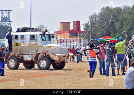 CARLETONVILLE, SOUTH AFRICA: Gold miners gather at Gold Fields KDC West Mine under the watch of police members on September 13, 2012 in Carletonville, South Africa. Miners have embarked on an illegal strike to air their labour grievances and their unhappiness with the leadership of the National Union of Mineworkers. (Photo by Gallo Images / Dino Lloyd) Stock Photo