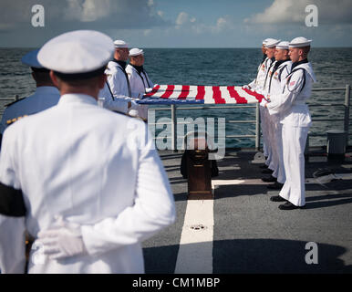 Members of the US Navy ceremonial guard hold an American flag over the remains of Apollo 11 astronaut Neil Armstrong during the burial at sea service for her husband Apollo 11 astronaut Neil Armstrong September 14, 2012 aboard the USS Philippine Sea in the Atlantic Ocean. Armstrong, the first man to walk on the moon during the 1969 Apollo 11 mission, died August 25. He was 82. Stock Photo
