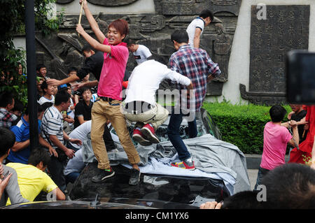 Xian, China. Saturday 15th September, 2012. Anti-Japanese protesters damage and break a Japanese brand car during a demonstration in downtown Xi'an,China,on Saturday Sept 15, 2012. Fights broke out between demonstrators and police during a march by more than 10,000 students, who were protesting at the sovereignty of the Fishing Islands(Diaoyu Islands). Stock Photo
