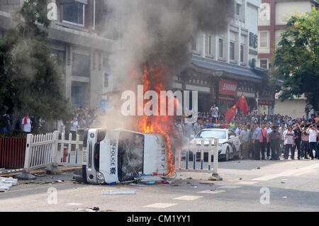 Xian, China. Saturday 15th September, 2012. Anti-Japanese protesters burn a car during a demonstration at Bell Tower Hotel in Xi'an,China,on Saturday Sept 15, 2012. Fights broke out between demonstrators and police during a march by more than 10,000 students, who were protesting at the sovereignty of the Fishing Islands(Diaoyu Islands). Stock Photo