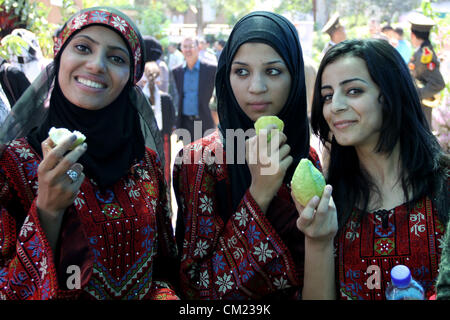 Sept. 17, 2012 - Qalqilya, West Bank, Palestinian Territory - Palestinian girls wear traditional dress and eat guava fruits, during the guava festival in the West Bank city of Qalqilya, Sept. 17, 2012  (Credit Image: © Nedal Eshtayah/APA Images/ZUMAPRESS.com) Stock Photo