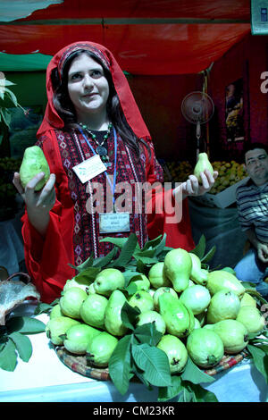 Sept. 17, 2012 - Qalqilya, West Bank, Palestinian Territory - A Palestinian girl wears a traditional dress and displays guava fruits, during the guava festival in the West Bank city of Qalqilya, Sept. 17, 2012  (Credit Image: © Nedal Eshtayah/APA Images/ZUMAPRESS.com) Stock Photo