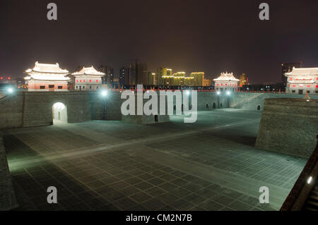 Newly constructed parts of the old city wall are illuminated by lamps in the early evening. The city centre undergoing major construction works on the old wall. The Mayor of Datong’s regeneration programme aims to distance the area from its recent coal-mining fame, and return the area instead to its past glory and historical significance. © Olli Geibel Stock Photo
