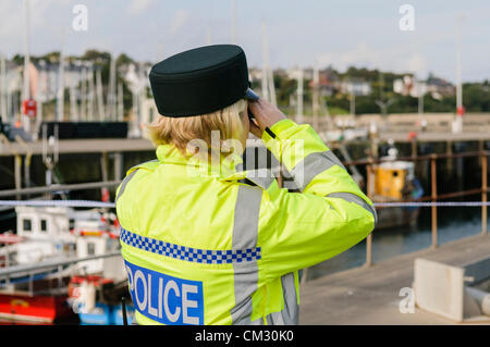 PSNI officer using binoculars to check on a rescue operation at sea Stock Photo
