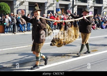 Munich, Germany. 23rd September, 2012. The opening parade of the world's biggest beer-festival, Oktoberfest, proceeds through the city of Munich, Germany. Two hunters with a dead wild pig were part of 8900 participants of this public parade. Stock Photo