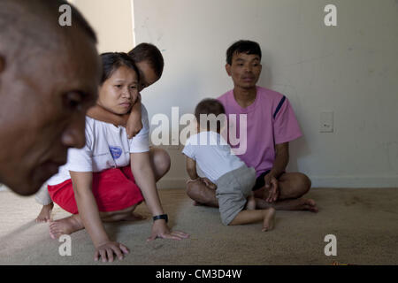 July 21, 2012 - Indianapolis, Indiana, U.S - In Indianapolis, Indiana a community of Karen and Karenni ethnic cultures, refugees from Myanmar (Burma) bordering with Thailand, share a new village much different from their native land.  A Karenni ethnic family with visitor inside their apartment at Lakeside Pointe. (Credit Image: © Gary Dwight Miller/ZUMAPRESS.com) Stock Photo