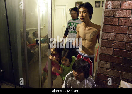 May 19, 2012 - Indianapolis, Indiana, U.S - In Indianapolis, Indiana a community of Karen and Karenni ethnic cultures, refugees from Myanmar (Burma) bordering with Thailand, share a new village much different from their native land.  A Karen ethnic Burmese refugee family looks into the dark of the night at Lakeside Pointe apartments. (Credit Image: © Gary Dwight Miller/ZUMAPRESS.com) Stock Photo