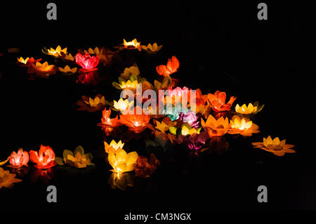Paper lotus flowers with candles float on a river at night to mark the Chinese Mid-Autumn Festival Stock Photo