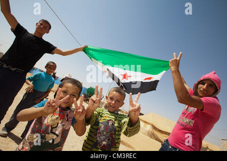 Anti Assad protesters march in the streets at the Zaatari Refugee Camp in Jordan on Thursday Sept 27 2012. The old style Syrian flags are being used. Stock Photo