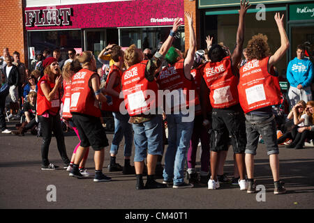 Bournemouth, UK Saturday 29 September 2012. Opening day of the Bournemouth Arts by the Sea Festival - the Big Issue Vendor Flash Mob perform. Lee Hart, Director of Salt Factory, worked with local Big Issue vendors to develop choreography which tells their stories. Stock Photo