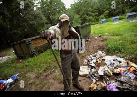 Aug. 23, 2012 - Sapelo Island, Georgia, U.S. - State of Georgia Department of Natural Resources employee STANLEY WALKER wipes his face while maintaining the trash dump. State employees and residents must haul their trash to the dump and maintain the site. (Credit Image: © Stephen Morten/zReportage.com/ZUMA) Stock Photo