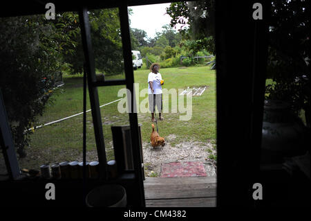 Aug. 23, 2012 - Sapelo Island, Georgia, U.S. - CORNELIA BAILEY walks her dog in the yard outside her trailer-home in the Geechee-Gullah community of Hog Hammock. (Credit Image: © Stephen Morten/zReportage.com/ZUMA) Stock Photo