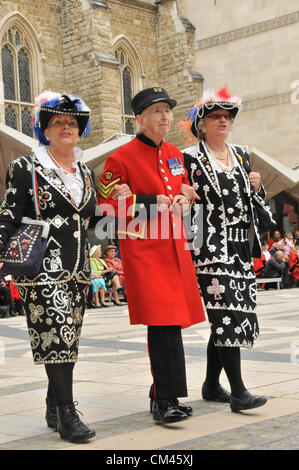 Guildhall Yard, London, UK. 30th September 2012. Pearly Queens and a Chelsea Pensioner. The Pearly Kings and Queens Harvest Festival in Guildhall Yard. A Cockney annual event with Maypole Dancers, Morris Men, a marching band and Pearly Kings & Queens from all over London. Stock Photo