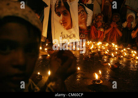 Supporters of PASBAN lighten lamps and offer Dua for  health recovery of Malala Yousaf Zai during a demonstration at Karachi press club on Friday,  October 12, 2012. Pakistan Government has called for Friday to be observed as a 'day of prayer'  for the recovery of a Fourteen years old girl shot in the head by Taliban gunmen. Stock Photo