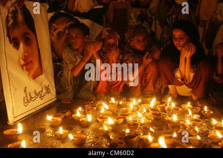 Supporters of PASBAN lighten lamps and offer Dua for  health recovery of Malala Yousaf Zai during a demonstration at Karachi press club on Friday,  October 12, 2012. Pakistan Government has called for Friday to be observed as a 'day of prayer'  for the recovery of a Fourteen years old girl shot in the head by Taliban gunmen. Stock Photo