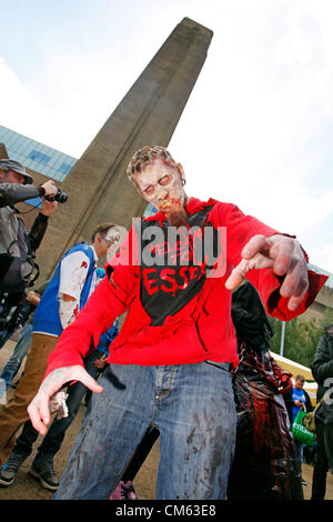 UK, London. 13th October 2012. Participants dressed as zombies in front of the Tate Modern at World Zombie Day, London fund-raising charity walk to raise awareness and help relieve hunger and homelessness. 50 cities worldwide participate. Stock Photo