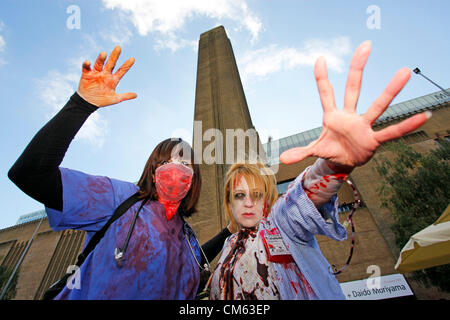 UK, London. 13th October 2012. Participants dressed as zombies in front of the Tate Modern at World Zombie Day, London fund-raising charity walk to raise awareness and help relieve hunger and homelessness. 50 cities worldwide participate. Stock Photo