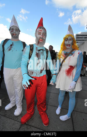 Southbank, London, UK. 13th October 2012. Three 'Zombie' Smurfs on the Southbank. World Zombie Day, a Zombie themed pub crawl through central London. Hundreds of people dressed as Zombies make their way through London on a day long charity pub crawl. Stock Photo