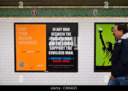 New York, NY, October 13, 2012.  Man walks past side-by-side advertisements, one promoting tolerance of Muslims the other denouncing Jihad, in the Times Square subway station. Stock Photo