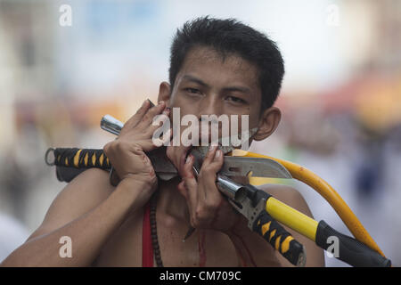 Oct. 19, 2012 - Phuket, Thailand - Devotees to the Chinese shrine of  Ban Tha Rue walk in a street procession at the annual Vegetarian Festival in Phuket, Thailand, Friday, Oct. 19, 2012. The annual traditional Chinese vegetarian festival  emphasizes merit making and ritual cleansing of the body to mark the nine-day-long festival featuring face-piercing, spirit mediums, and strict vegetarianism. (Credit Image: © David Longstreath/ZUMAPRESS.com) Stock Photo