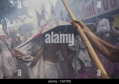 Oct. 19, 2012 - Phuket, Thailand - A man shields himself from exploding fireworks during a street procession at the annual Vegetarian Festival. The annual tradition sees devotees of the Chinese shrine of Ban Tha Rue emphasize merit making and ritual cleansing of the body to mark the nine-day-long festival featuring face-piercing, spirit mediums, and strict vegetarianism. (Credit Image: © David Longstreath/ZUMAPRESS.com) Stock Photo