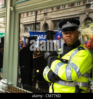 Police stand guard outside Fortnum & Mason during the TUC 'A Future That Works March' in London on 20/10/2012. Marchers may be seen reflected in the shop windows. The shop was occupied in the 2011 march. Picture by Julie Edwards Stock Photo