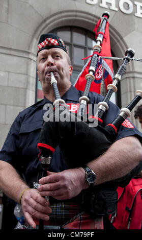 Scottish Fire Brigade Union member play bagpipe during Trade Unions' Coalition for Resistance anti-cuts rally in London Stock Photo