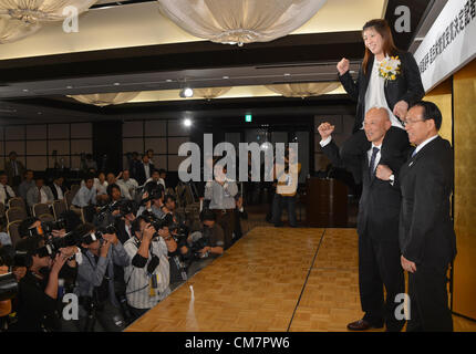 October 23, 2012, Tokyo, Japan - Saori Yoshida, Japan's three-time Olympic wrestling champion, rides on the shoulders of her coach Kazuhito Sakae, posing for photographers after a news conference in Tokyo on Tuesday, October 23, 2012. Japanese government decided to bestow the People's Honor Award on her for 'bringing hope and courage to society.' Yoshida,30, won a total of 13 Olympic and world titles in women's wrestling. At right is Tomiaki Fukuda, president of the Japan Wrestling Federation. (Photo by Natsuki Sakai/AFLO) AYF -mis- Stock Photo