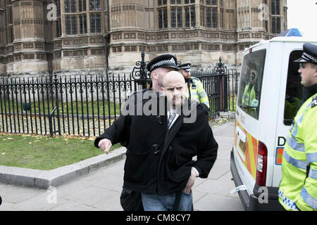 An EDL member being escorted back to a pen outside parliament after confronting members of an opposing group. Stock Photo