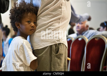 Jerusalem, Israel. 31st October 2012. A young boy hides behind his father’s back at a ceremony opening the Sigd festivities in the President’s Residence. Jerusalem, Israel. 31-Oct-2012.  President Peres opens the Sigd festivities, hosting children and dignitaries from the Jewish Ethiopian community, Beta-Israel, at his residence. The Sigd symbolizes Beta-Israel’s yearning for Jerusalem while living in seclusion for over 1,000 years. Credit:  Nir Alon / Alamy Live News Stock Photo