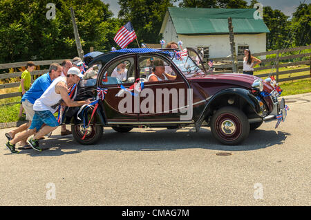 Niantic, Connecticut, July 4, 2012 - Residents celebrate Independence Day with the 40th Annual Black Point Beach Club Parade. Neighbors help this antique auto, which stalled out, get going back in the parade. Stock Photo