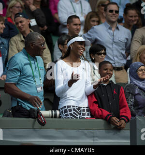 07.07.2012. The Wimbledon Tennis Championships 2012 held at The All England Lawn Tennis and Croquet Club, London, England, UK.  Serena WILLIAMS (USA) [6] v Agnieszka RADWANSKA (POL) [3] . Venus Williams (with her father on left) in the players' box shares a joke with her sister Serena who has just been presented with her trophy for winning the Ladies Singles finl. Stock Photo